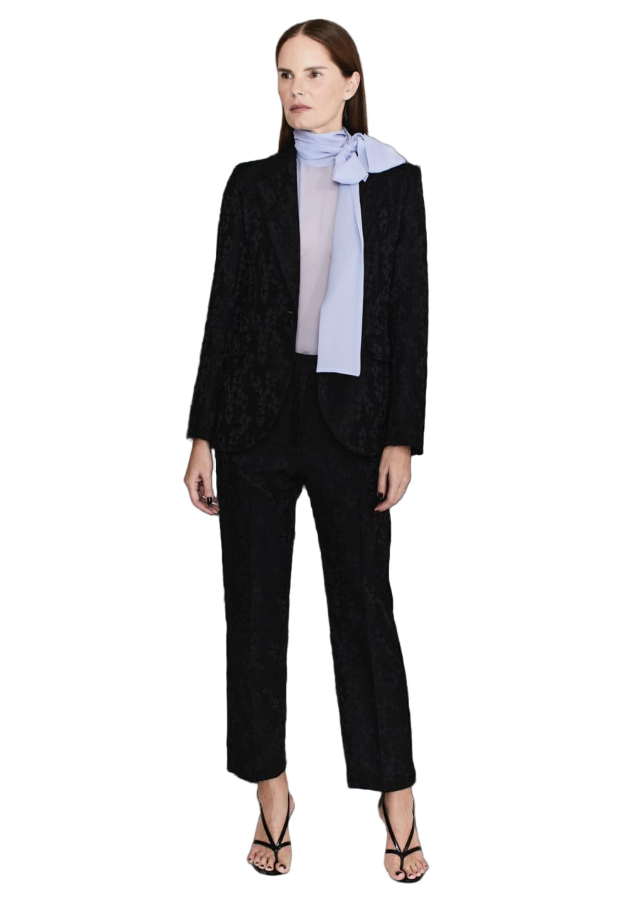 Woman wearing a black suit with a light blue blouse on a white background