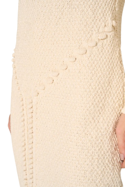 Close-up of a textured beige dress with button details.