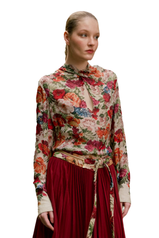 Woman wearing a floral blouse and red skirt on a white background