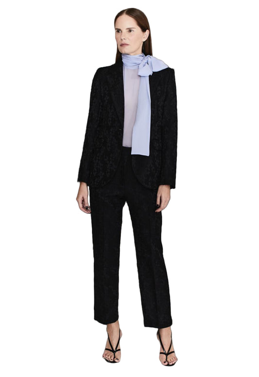 Woman wearing a black suit with a light blue blouse on a white background